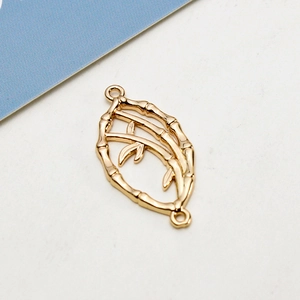 Macro shot of gold bamboo leaf pendant connectors for DIY jewelry making and necklaces