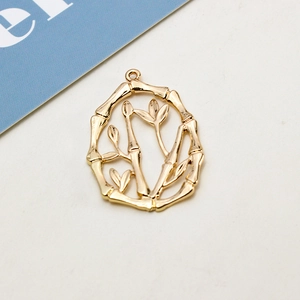 Detailed macro view of a golden bamboo branch pendant with hollow oval design for DIY jewelry