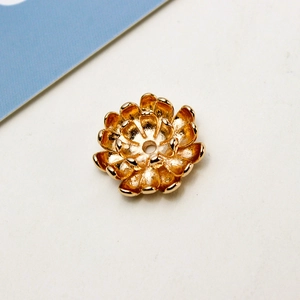 Detailed macro view of a golden lotus petal jewelry charm with a central threading hole