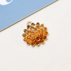 Detailed top view of a gold lotus charm with multi-layered petals and a small hanging loop
