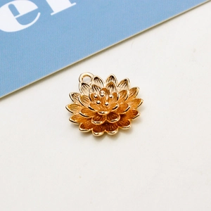 Close-up of golden lotus flower pendant charm with multilayered petals and a top hanging loop