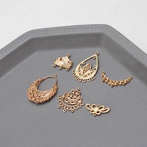Vue détaillée de six breloques métalliques dorées évidées et pendentifs en filigrane