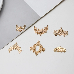 Macro detail of six vintage hollowed-out golden brass charms for DIY jewelry making