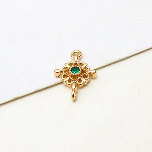 Macro view of gold-plated rhombic pendant connector with green zircon for DIY jewelry making