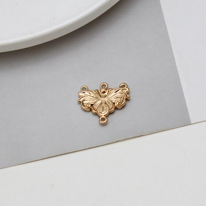 Détail macro d'un connecteur de bijoux en filigrane doré vintage avec quatre anneaux