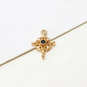 Macro shot of gold-plated hollow cross pendant with black zircon and dual connection loops