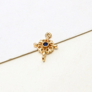 Close-up of gold-plated cross pendant with micro-set blue zircon for DIY jewelry making
