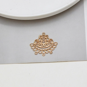 Vue macro d'un pendentif floral évidé doré avec neuf petits trous pour bijoux DIY