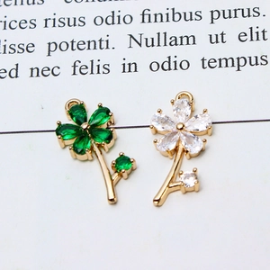 Macro detail of micro-paved zircon flower charms in emerald and clear gemstones