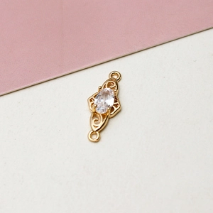 Detail of gold-plated jewelry connector with oval zircon and hollow filigree pattern
