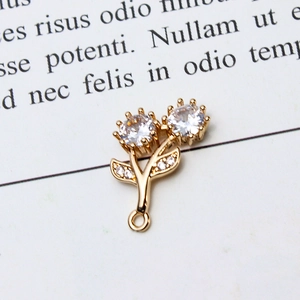 Macro detail of gold flower pendant with zircons and ring connector on book page