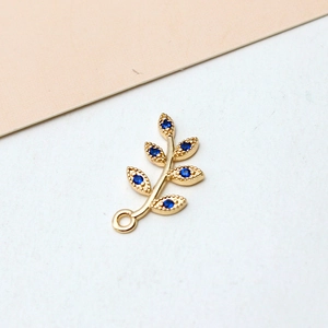 Detailed view of gold plated leaf pendant with dark blue zircon stone for DIY jewelry