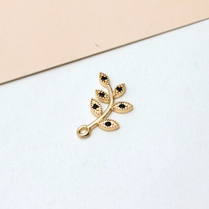 Detailed macro view of gold-plated leaf pendant with black zircon stones and jump ring