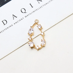 Detailed close-up of a pear-shaped gold-plated copper pendant with zircon inlays