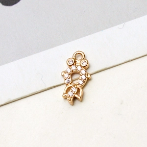 Detalle de dije de pez bañado en oro con circonitas para creación de joyas DIY