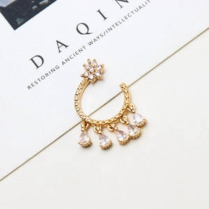 Detail of gold crescent moon pendant with micro-paved star and pear-cut zircon tassels