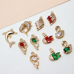 Detailed macro view of gold-plated dolphin and swan charms with micro-pave zircons