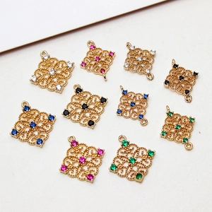 Macro view of vintage hollow diamond-shaped gold charms with colorful gemstones