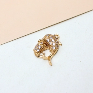 Macro detail of gold-plated dolphin pendants with micro-paved white zircon stones
