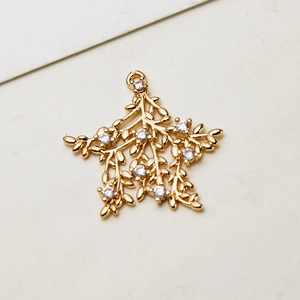 Makroaufnahme von vergoldetem Schneeflocken-Anhänger mit Zirkonia-Zweigen für DIY-Schmuck