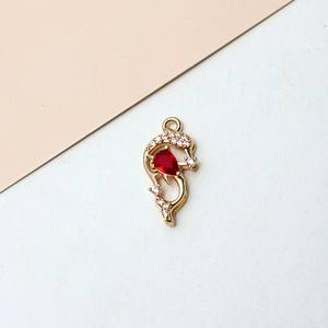 Detail of gold dolphin charm with red droplet zircon and white crystal pave setting