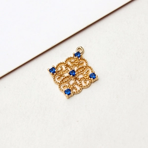 Detail of vintage gold-plated hollow rhombus pendant with sparkling blue rhinestones