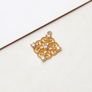 Close-up of vintage hollow rhombus pendant with gold plating and white zircons