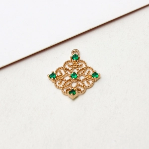 Detail of vintage gold-plated hollow rhombus pendant with sparkling green zircon stones