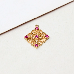 Detail of hollow rhombus gold pendant with pink zircons and vintage palace style craft