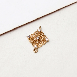 Macro shot of gold-plated hollow rhombus pendant connector with five zircon stones
