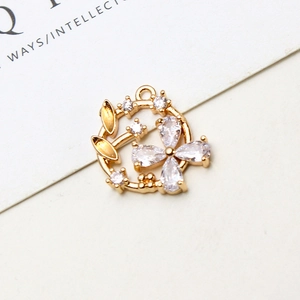 Makroaufnahme Goldener Blumenanhänger mit Zirkonia-Blütenblättern und Blattdetails