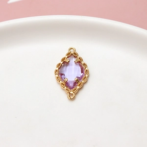 Detalle de colgante de cristal marquesa morado con marco dorado para joyería artesanal