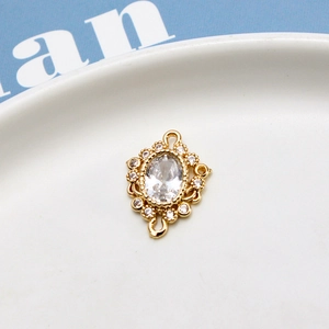 Detail of vintage gold pendant connector with oval zircon and Victorian style lace border