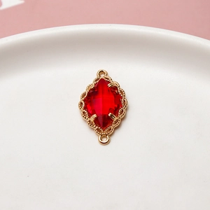 Vista macro detallada del colgante de cristal marquise rojo con filigrana dorada para joyas DIY