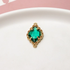 Detalle de colgante de cristal verde esmeralda con borde floral dorado para joyería DIY