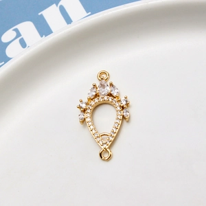 Macro view of gold crown pendant with cubic zirconia and dual loops for jewelry