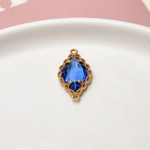Detalle macro del colgante de cristal azul marquesa con marco floral de oro fino
