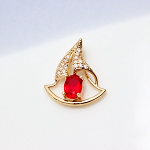 Macro view of gold-plated sailboat pendant featuring red oval stone and pavé zircon details