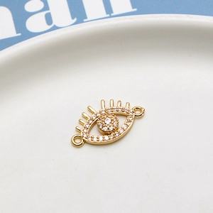 Macro view of gold-plated evil eye connector with micro-paved zircons and lash detail