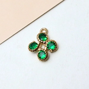 Détail macro du pendentif fleur à quatre feuilles doré 18 carats avec zircon vert