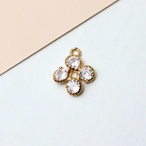 Détail macro d'un pendentif fleur plaqué or avec zircons pour la création de bijoux