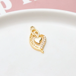 Macro view of gold-plated hollow heart pendant with zircons and greek meander pattern