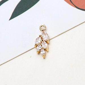 Macro detail of leaf-shaped gold plated pendant with five marquise-cut cubic zirconia