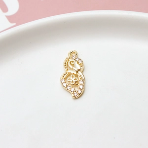 Macro shot of gold-plated hollow heart pendant with zircons on a white ceramic plate