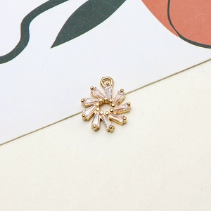 Macro shot of gold sunburst pendant with baguette-cut zircons for DIY jewelry making
