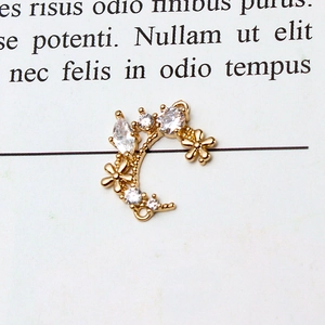 Detailed view of moon-shaped gold charm connector with sparkling zircon stones