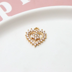 Macro shot of gold-plated heart pendant with zircon floral center for DIY jewelry