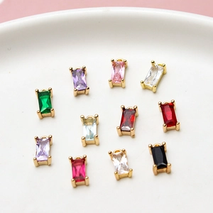 Macro view of colorful rectangular zircon pendants with gold-plated frames on a tray