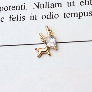Macro shot of a gold-plated deer pendant featuring a pear-cut white zircon stone