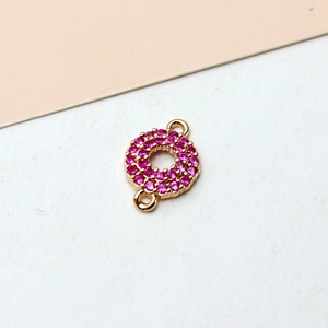 Detail eines vergoldeten Rundanhängers mit Doppelösen und rosa Pavé-Kristallen